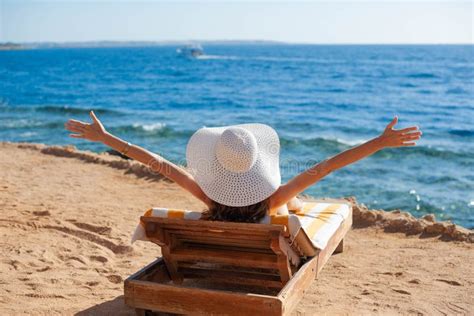 Des femmes se font bronzer seins nus sur une plage, les